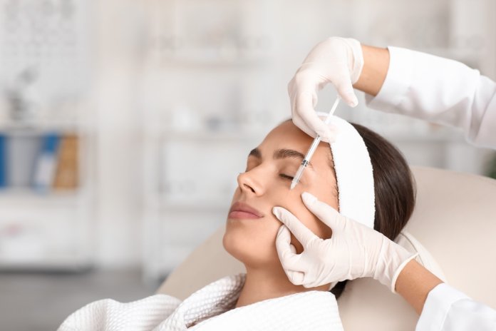 Young,Woman,Receiving,Cheek,Filler,Injection,In,Beauty,Salon