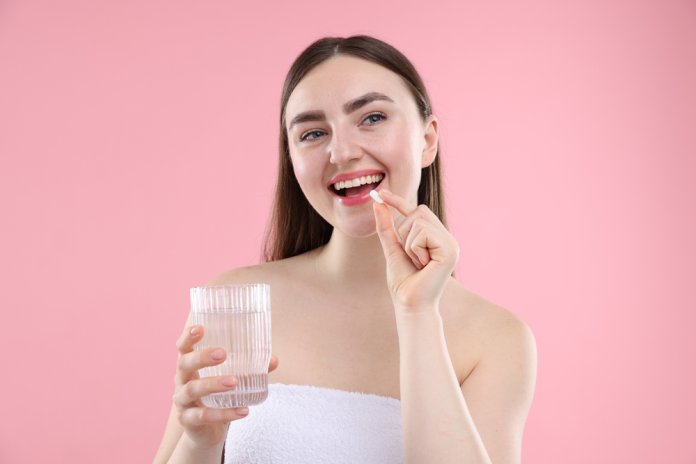 Happy,Woman,With,Glass,Of,Water,Taking,Collagen,Pill,On